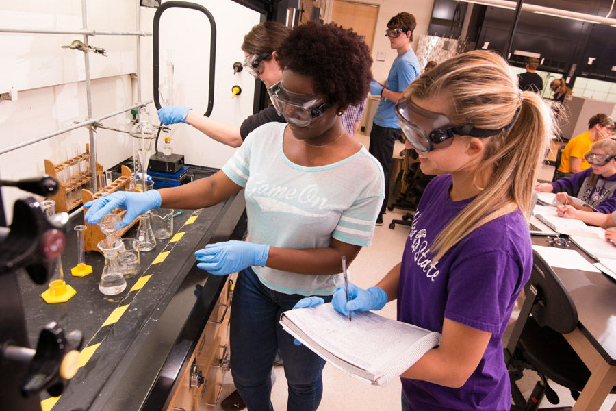 WSU students perform a chemical experiment in a lab.